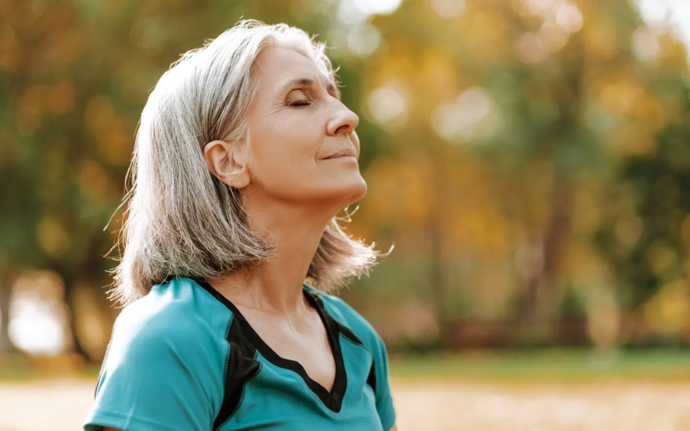 Beautiful senior woman breathing fresh air in park