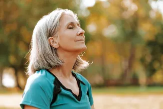 Beautiful senior woman breathing fresh air in park