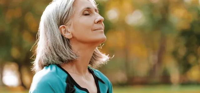 Beautiful senior woman breathing fresh air in park